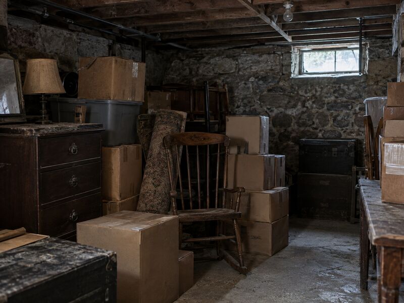 A basement packed with stored boxes and old furniture