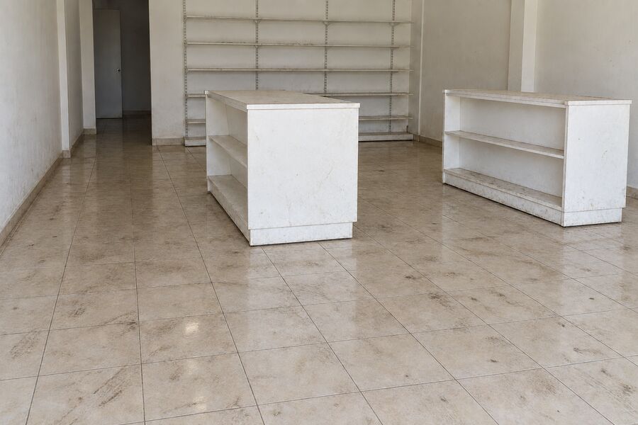 A retail sales floor grimy underfoot with marked fixtures