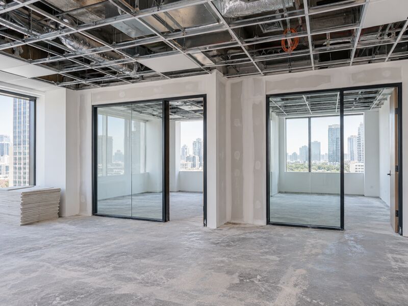 An office floor mid-fitout with new partitions and an exposed ceiling grid
