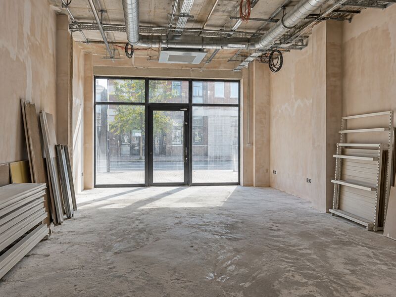 A retail unit mid-fitout with bare walls and exposed services