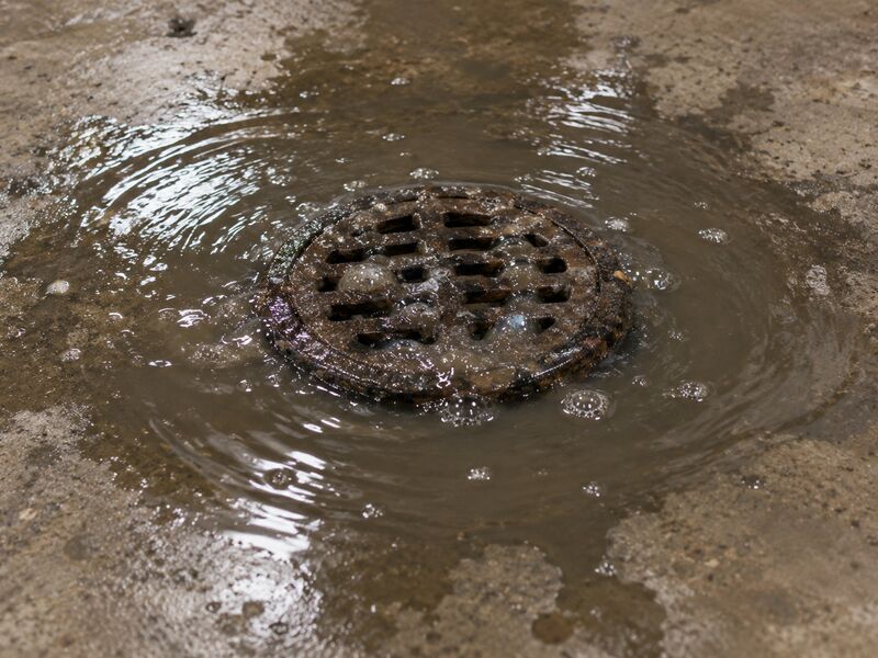 Dark water welling up around a basement floor drain